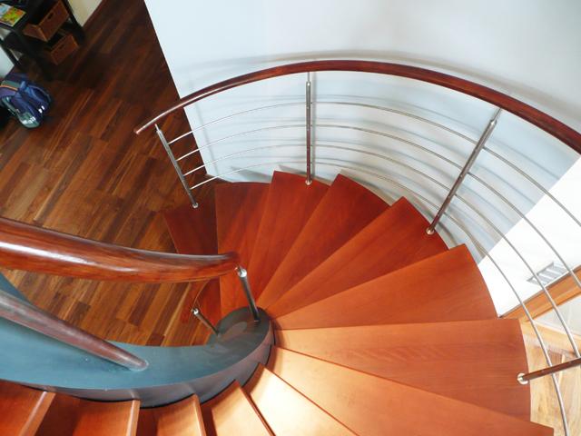 Wooden spiral staircase with a stainless steel railing